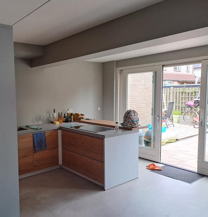 Opgeleverde aanbouw met keukenblok en openslaande deuren naar de tuin
