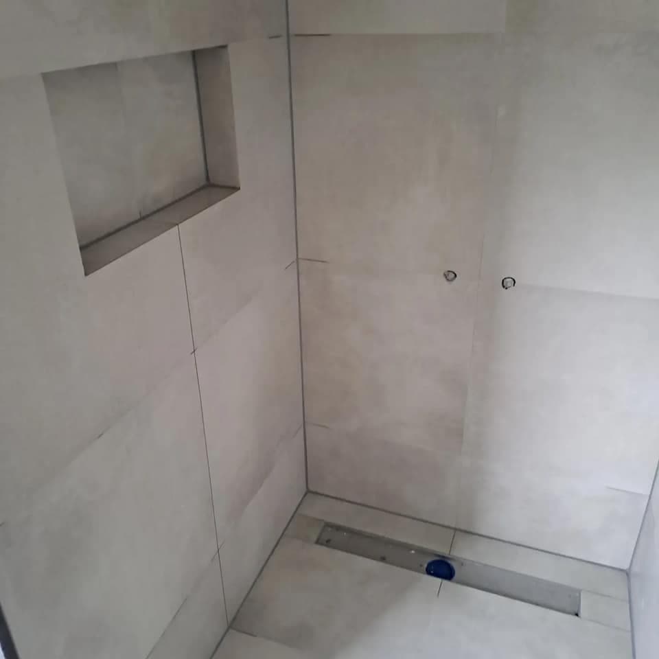 Betegelde inloopdouche met een nis in de wand en een lijngoot in de vloer