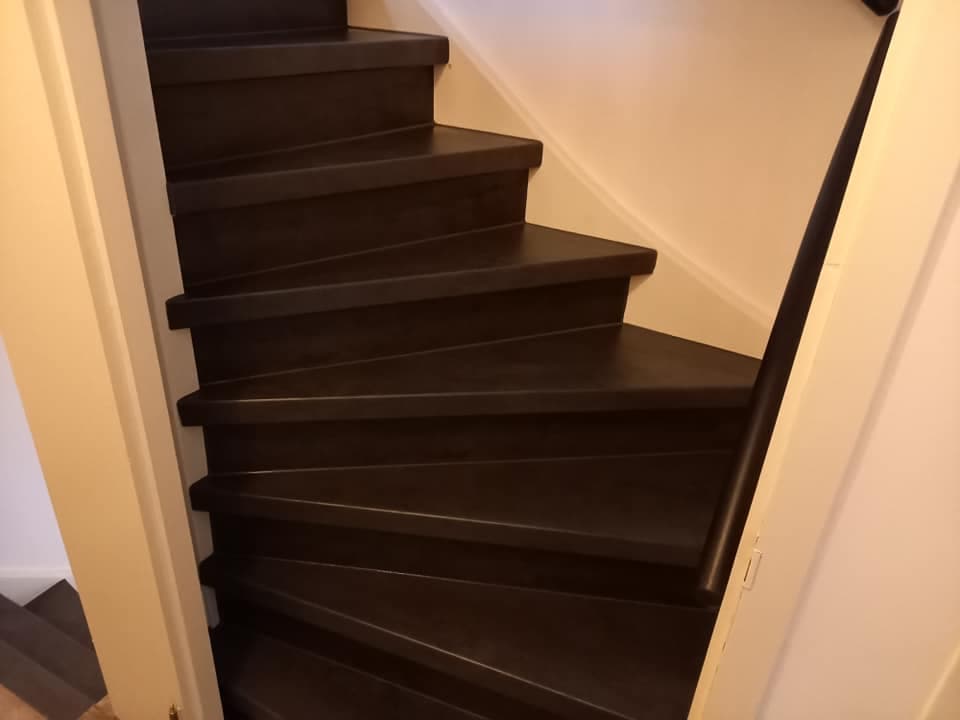 Gerenoveerde trap met donkere overzettreden en lichte stootborden