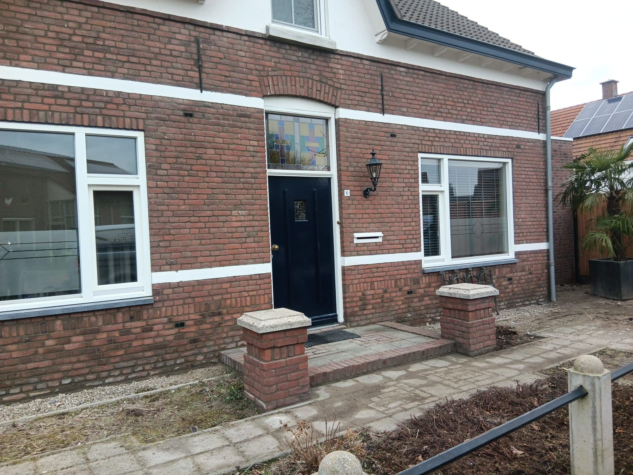 Gerenoveerde voorgevel met opnieuw gevoegd metselwerk, witte speklagen en nieuwe kozijnen